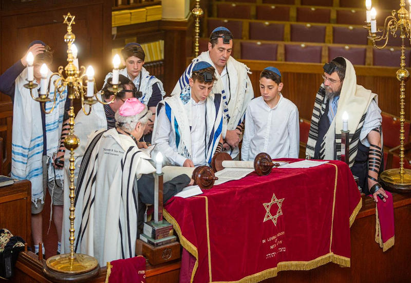 Jewish males surrounding table atBar Mitzvah